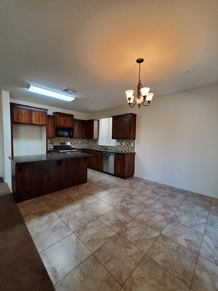 A kitchen with brown cabinets and a tiled floor.