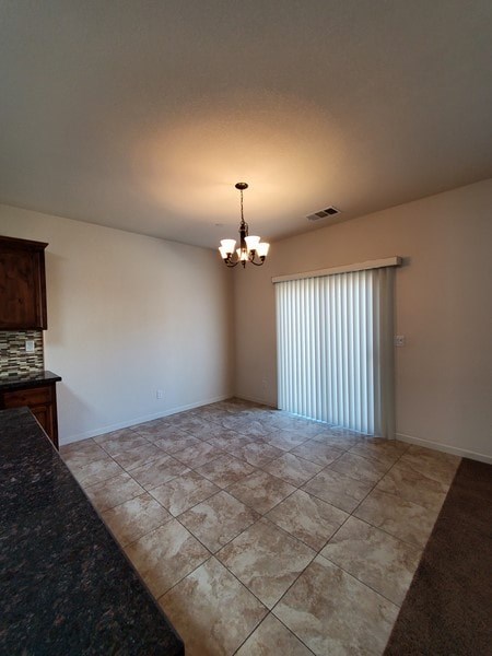 A room with a tiled floor and a chandelier hanging from the ceiling.