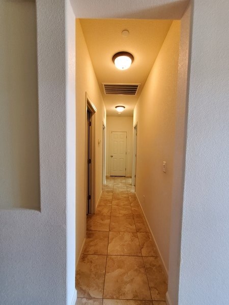 A long hallway with a white door at the end.