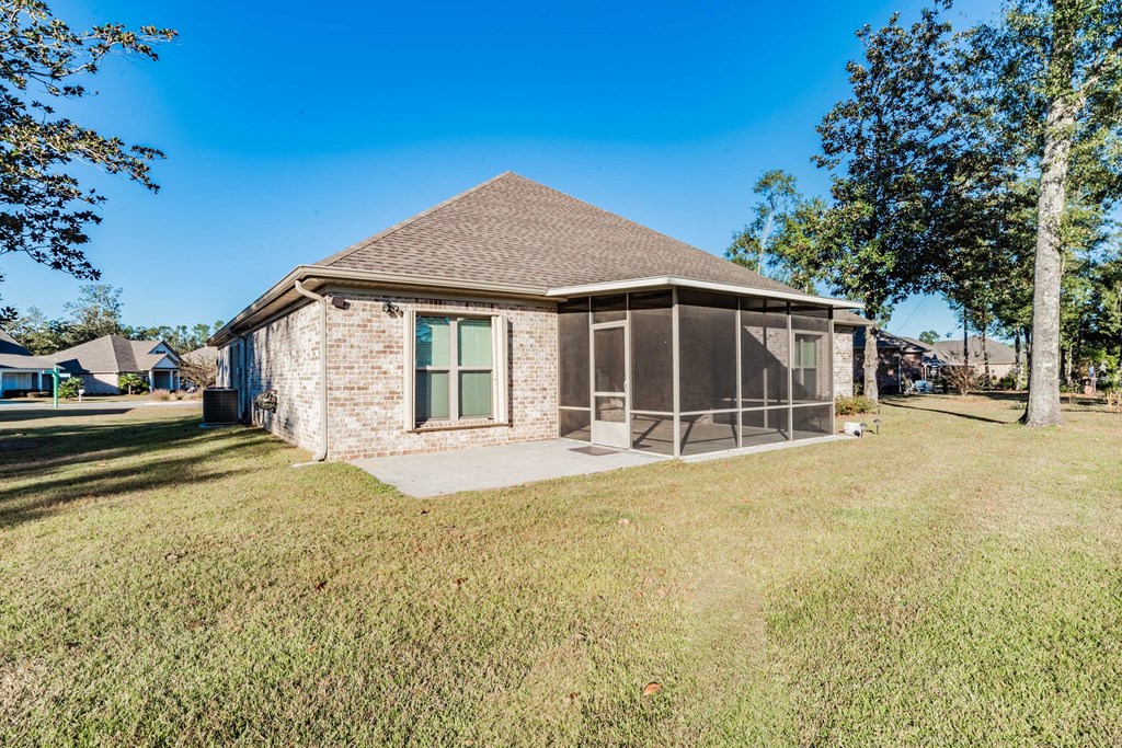 A house with a brown roof and a green lawn in front.