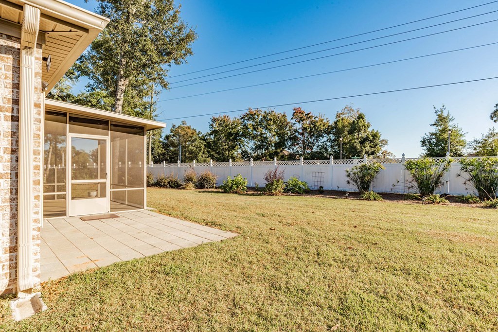 A house with a wooden deck and a white fence in the background.