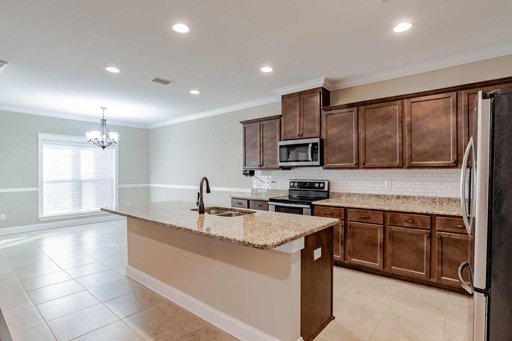A kitchen with a granite countertop and a refrigerator.