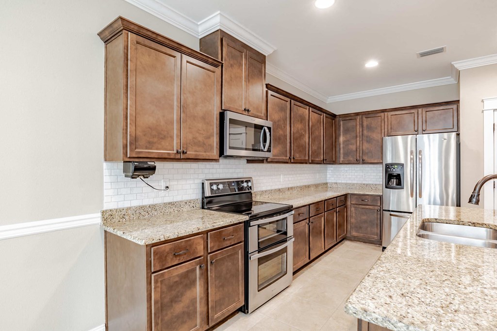 A kitchen with wooden cabinets and granite countertops.