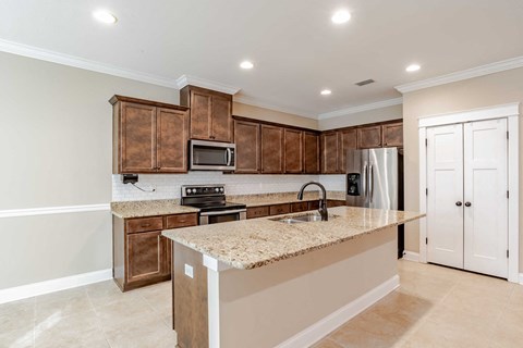 A kitchen with brown cabinets and a granite countertop.
