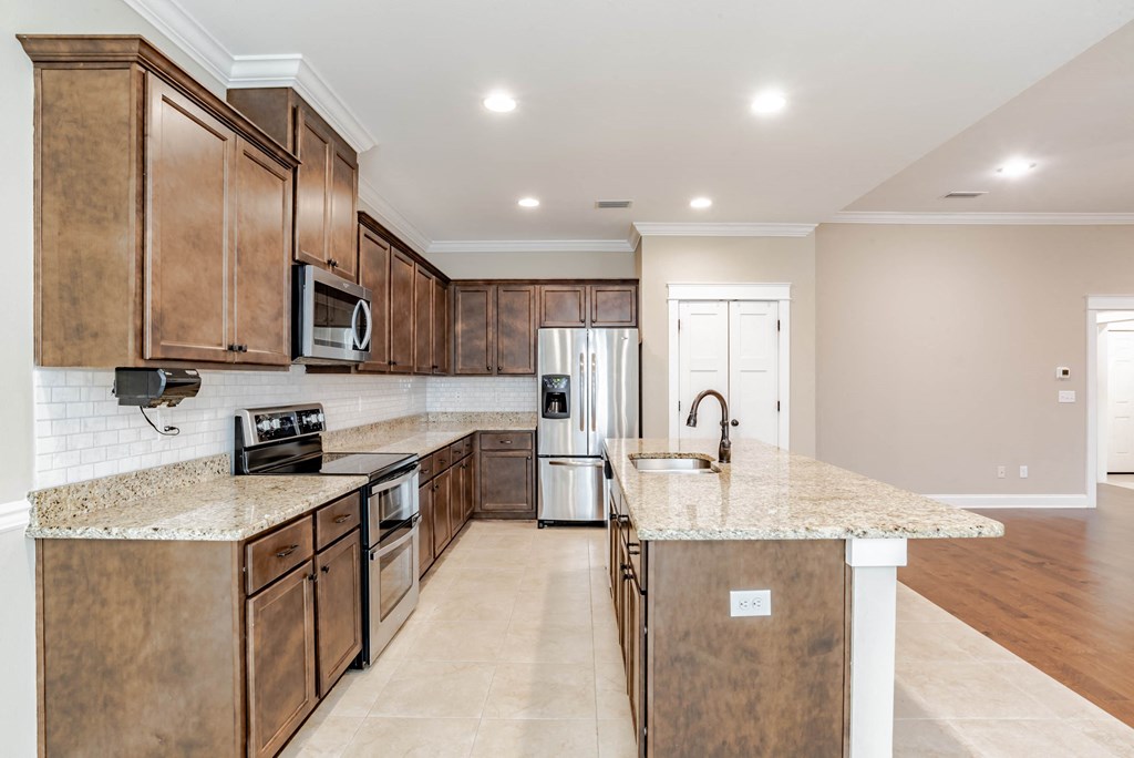 A kitchen with brown cabinets and granite countertops.