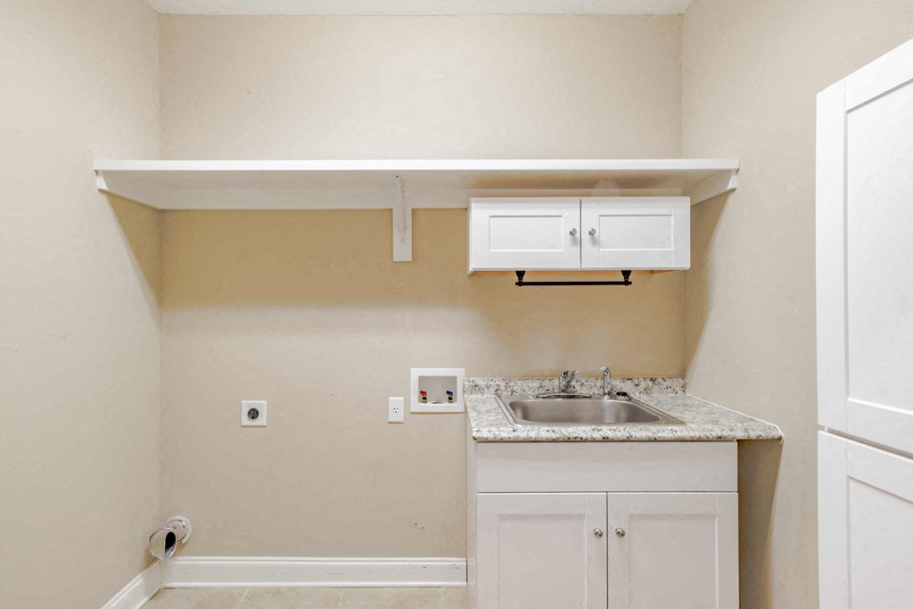 A kitchen with a sink and cabinets under a counter.