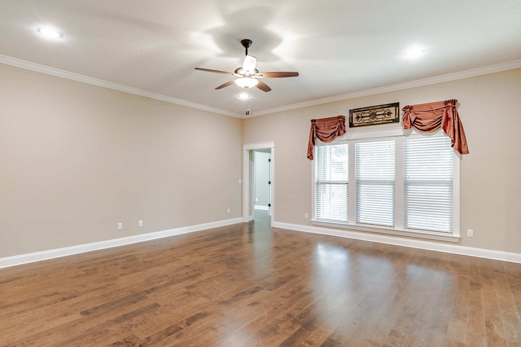 A room with a ceiling fan and a door.