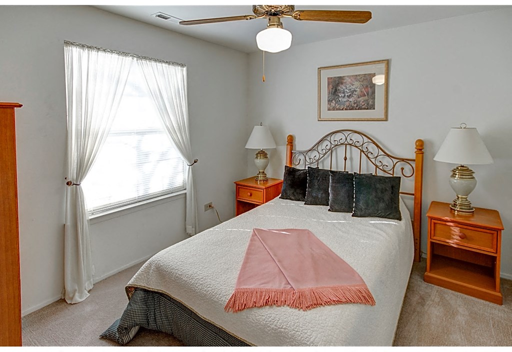 a bedroom with a bed and a ceiling fan