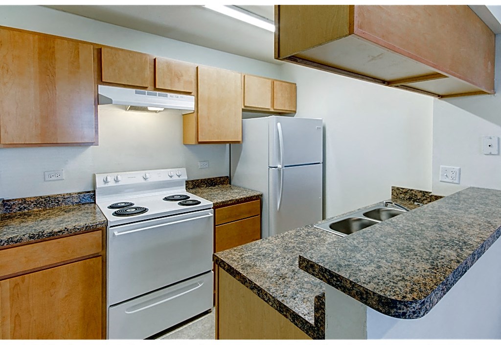 a kitchen with granite counter tops and white appliances