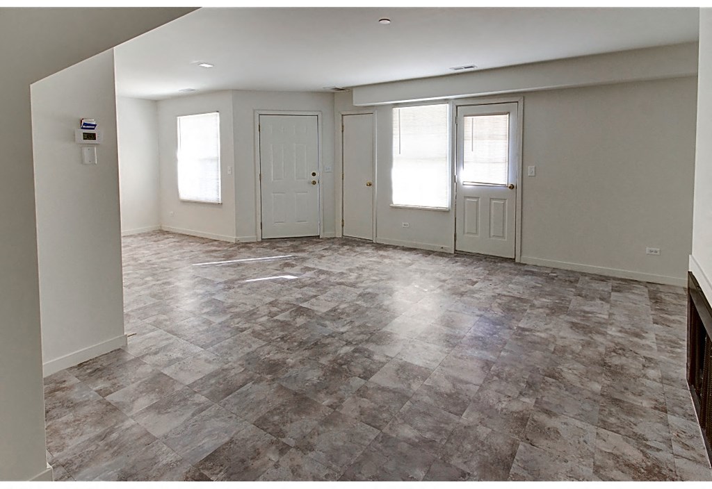 an empty living room with a tile floor and white walls