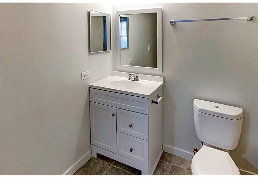 a bathroom with a sink toilet and a mirror