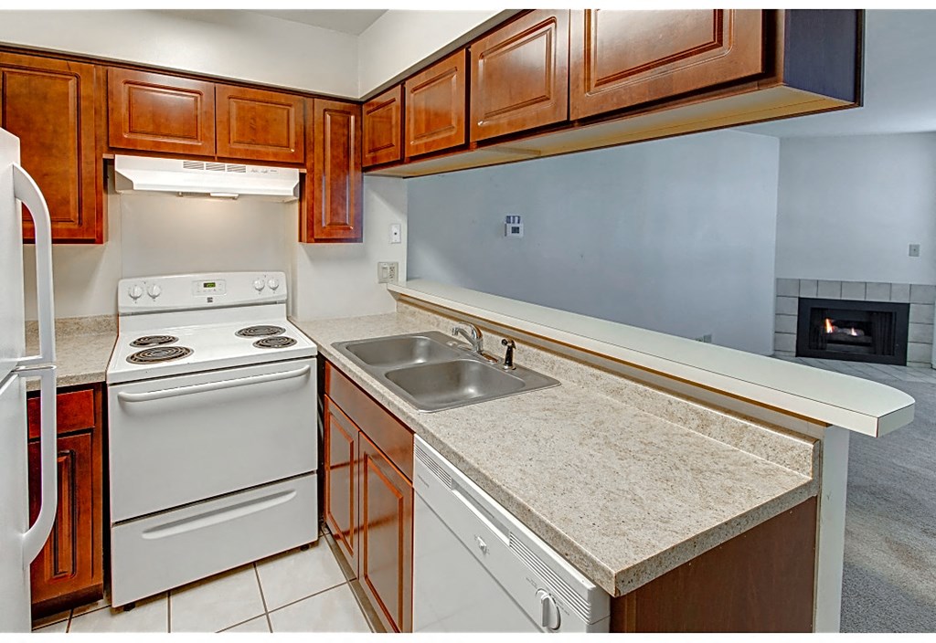 a kitchen with white appliances and wooden cabinets