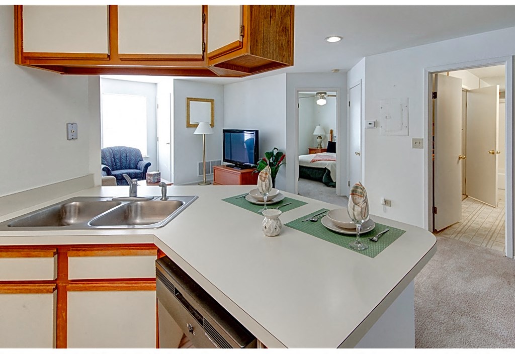 a kitchen with a white counter top and a sink