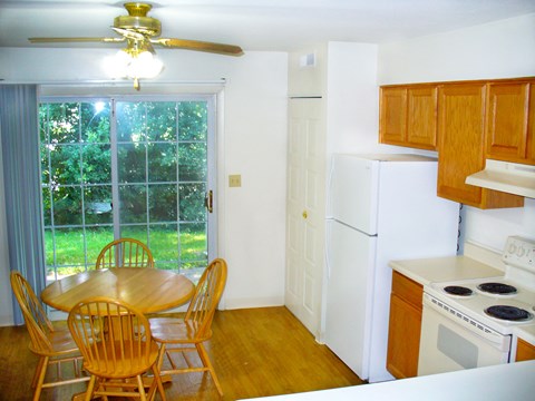 a kitchen with a table and chairs and a refrigerator