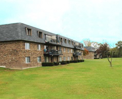 a large brick building on a green field