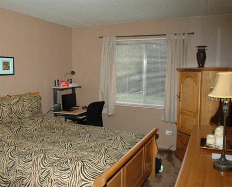 a bedroom with a bed and a desk and a window
