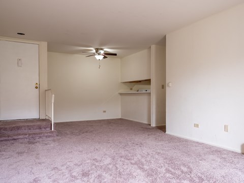 A room with a ceiling fan and a carpeted floor.