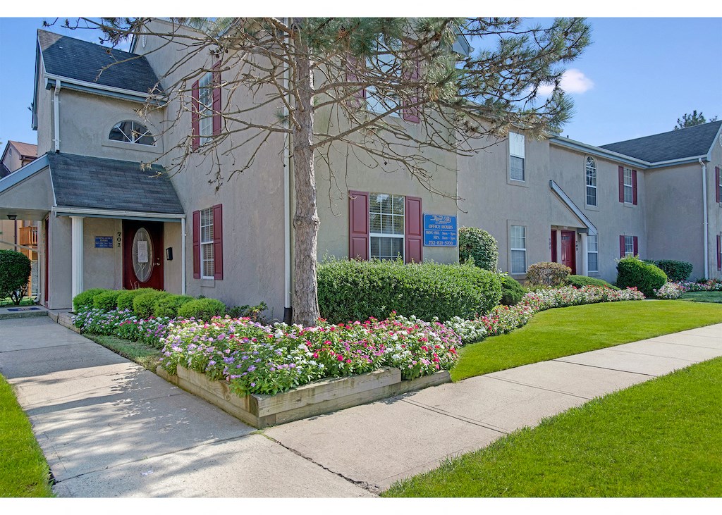 the front of a house with a flower garden in front of it