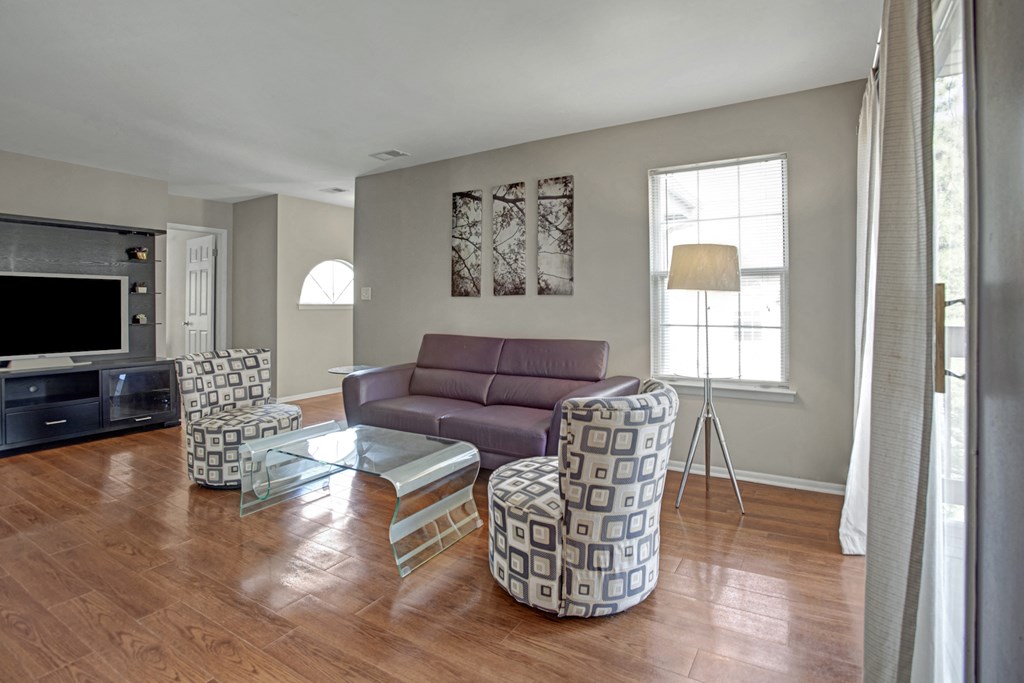 a living room with a couch and chairs and a tv