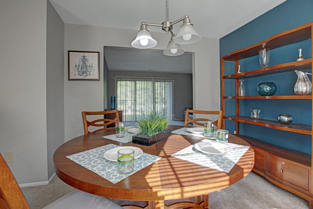 a dining room with a wooden table and a blue wall and a window