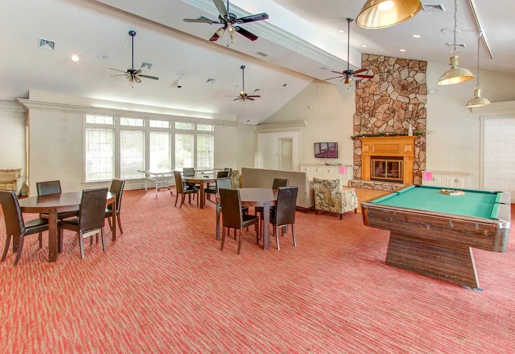 a game room with a pool table and tables