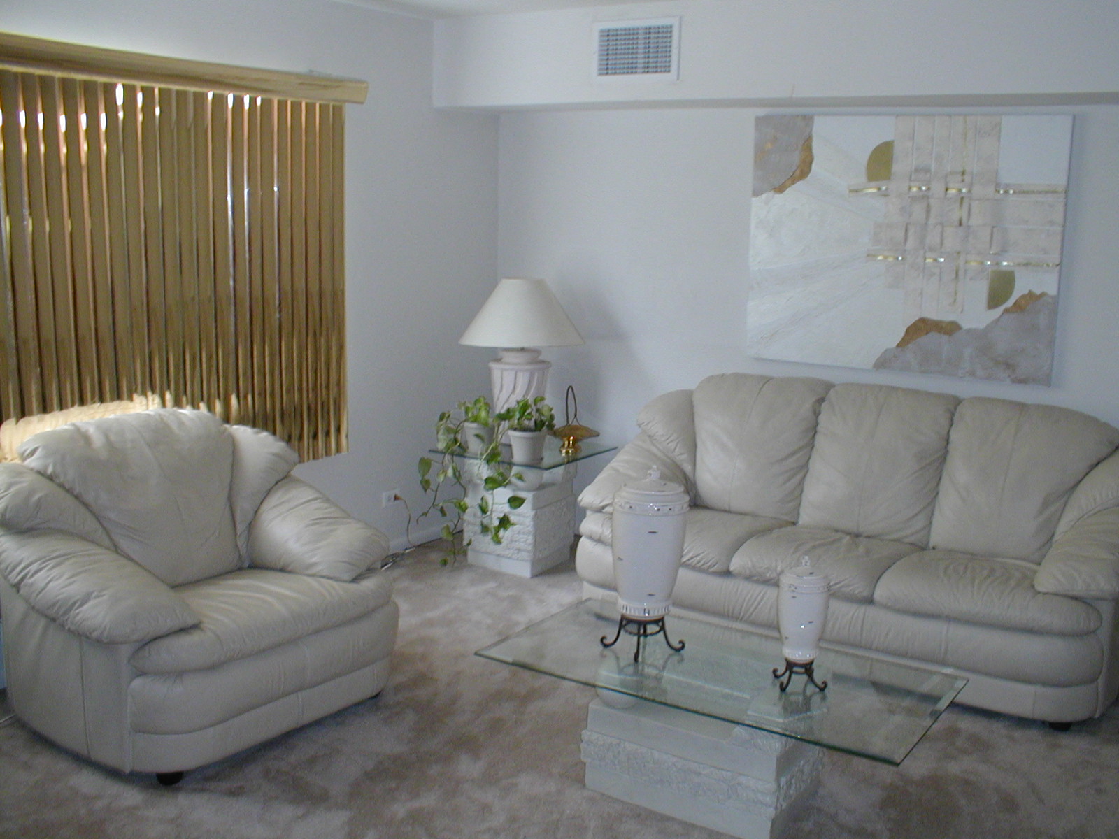 A living room with two couches and a table with a lamp on it.