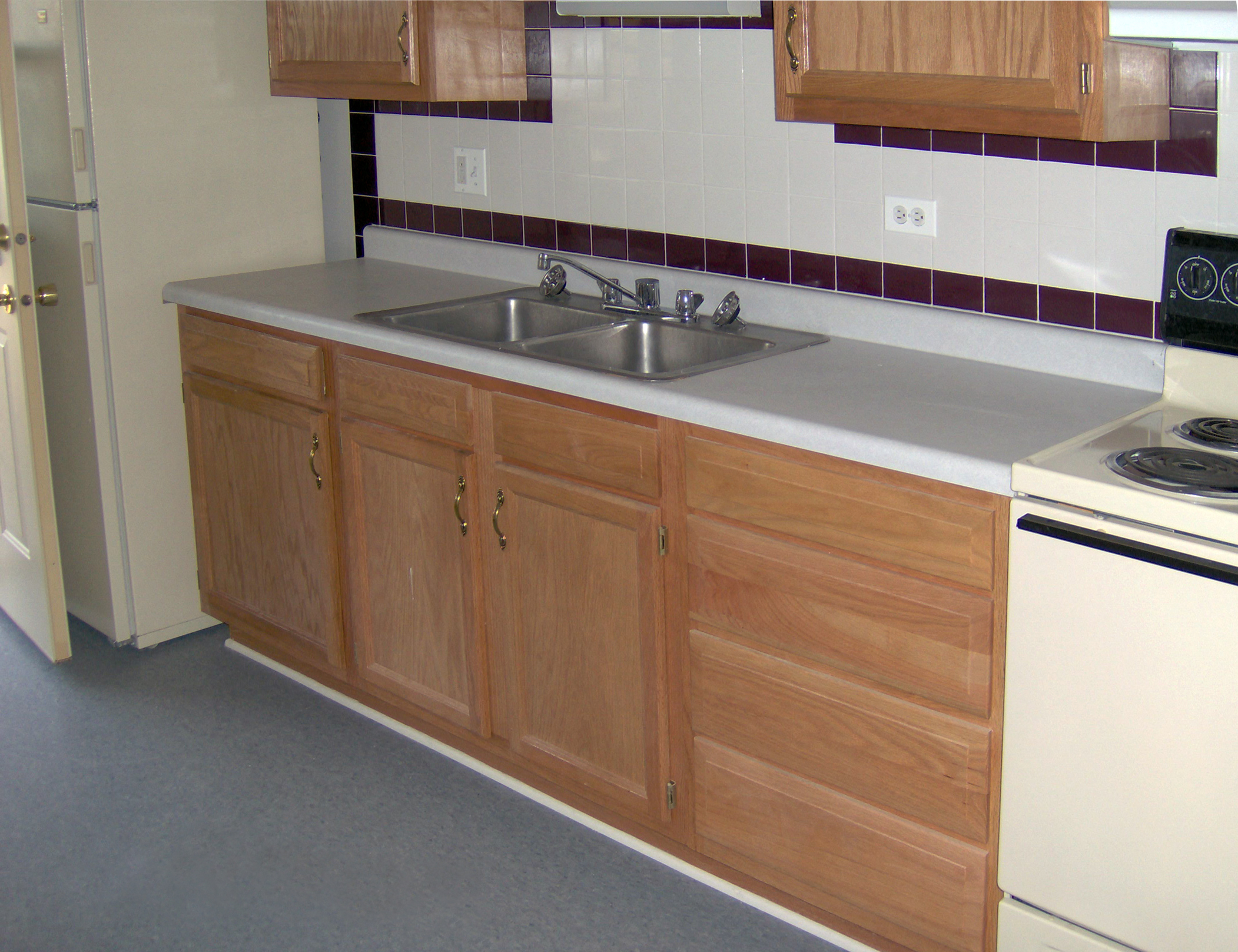 A kitchen with wooden cabinets and a white oven.