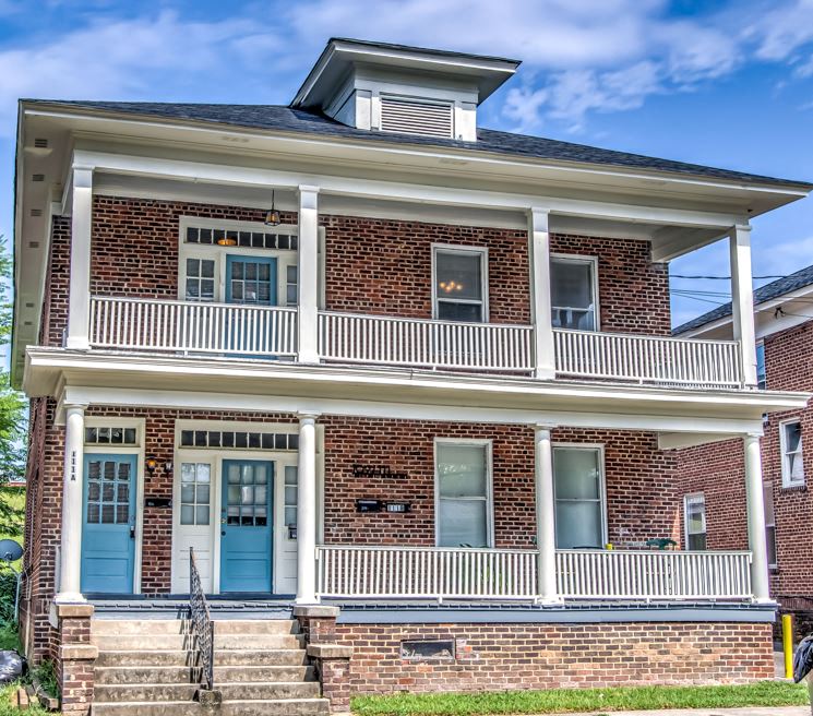 the front of a brick house with blue doors