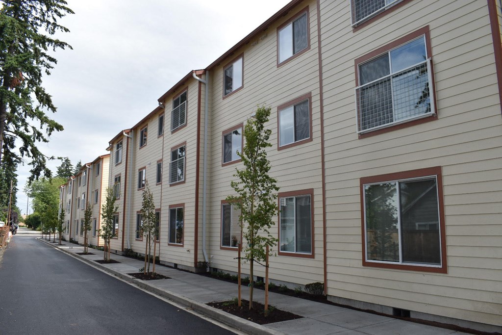 a row of town houses with trees in the sidewalk