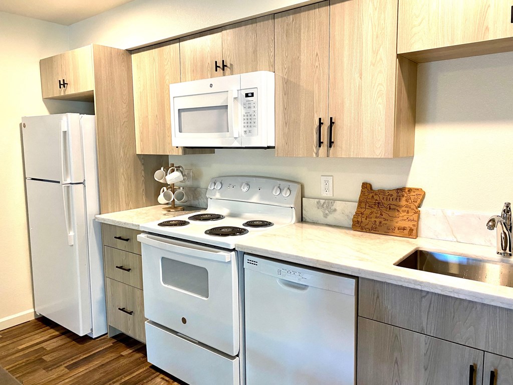 a kitchen with white appliances and wooden cabinets