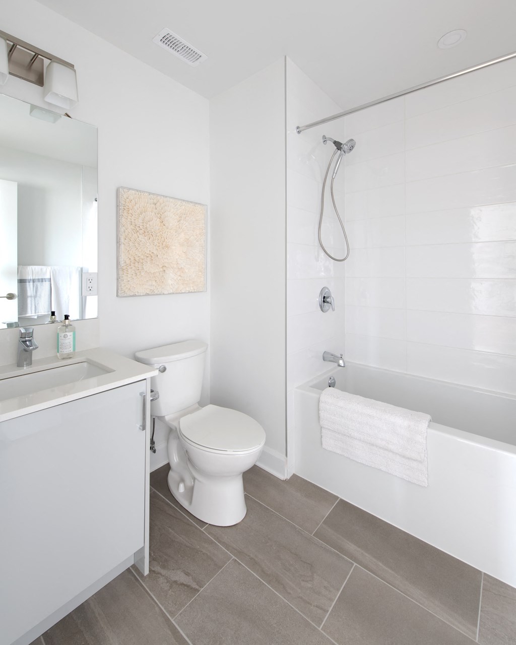 a white bathroom with a toilet and a shower