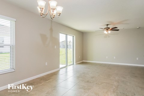 A spacious room with a ceiling fan and sliding glass doors.