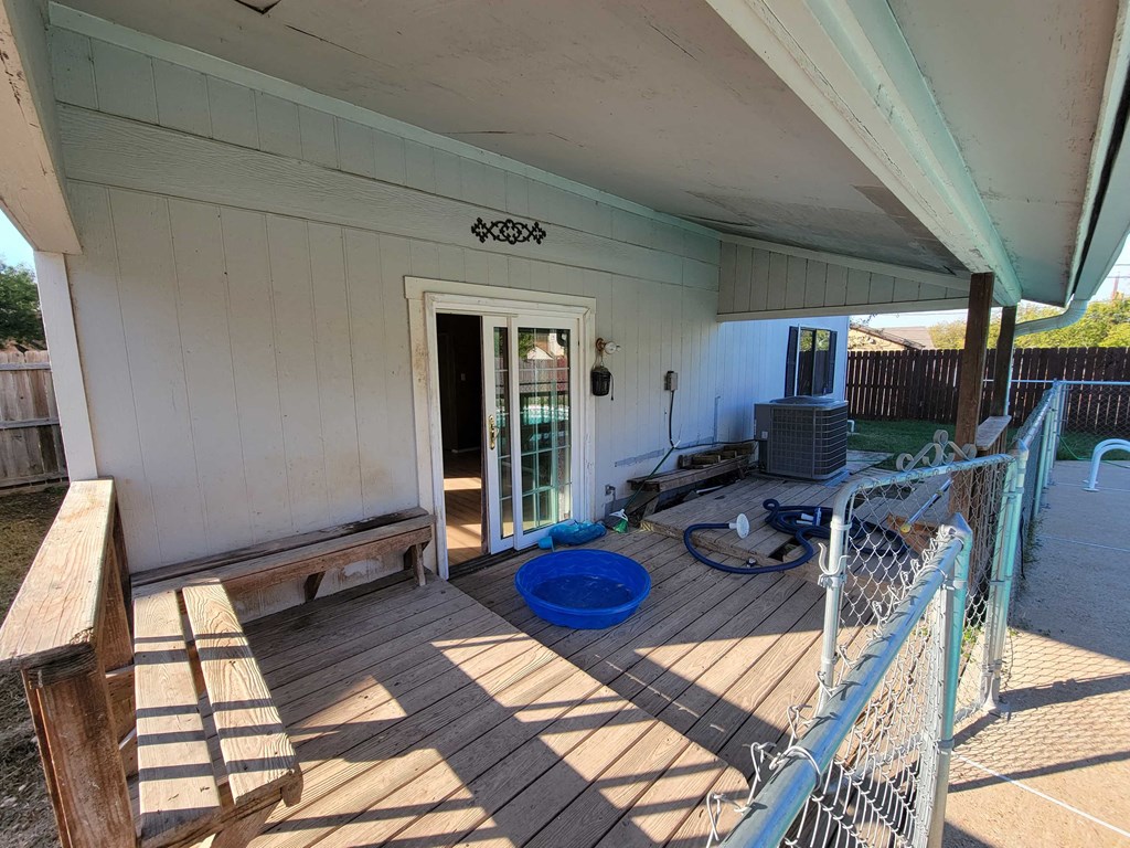 a porch with a door and a blue bowl on the floor