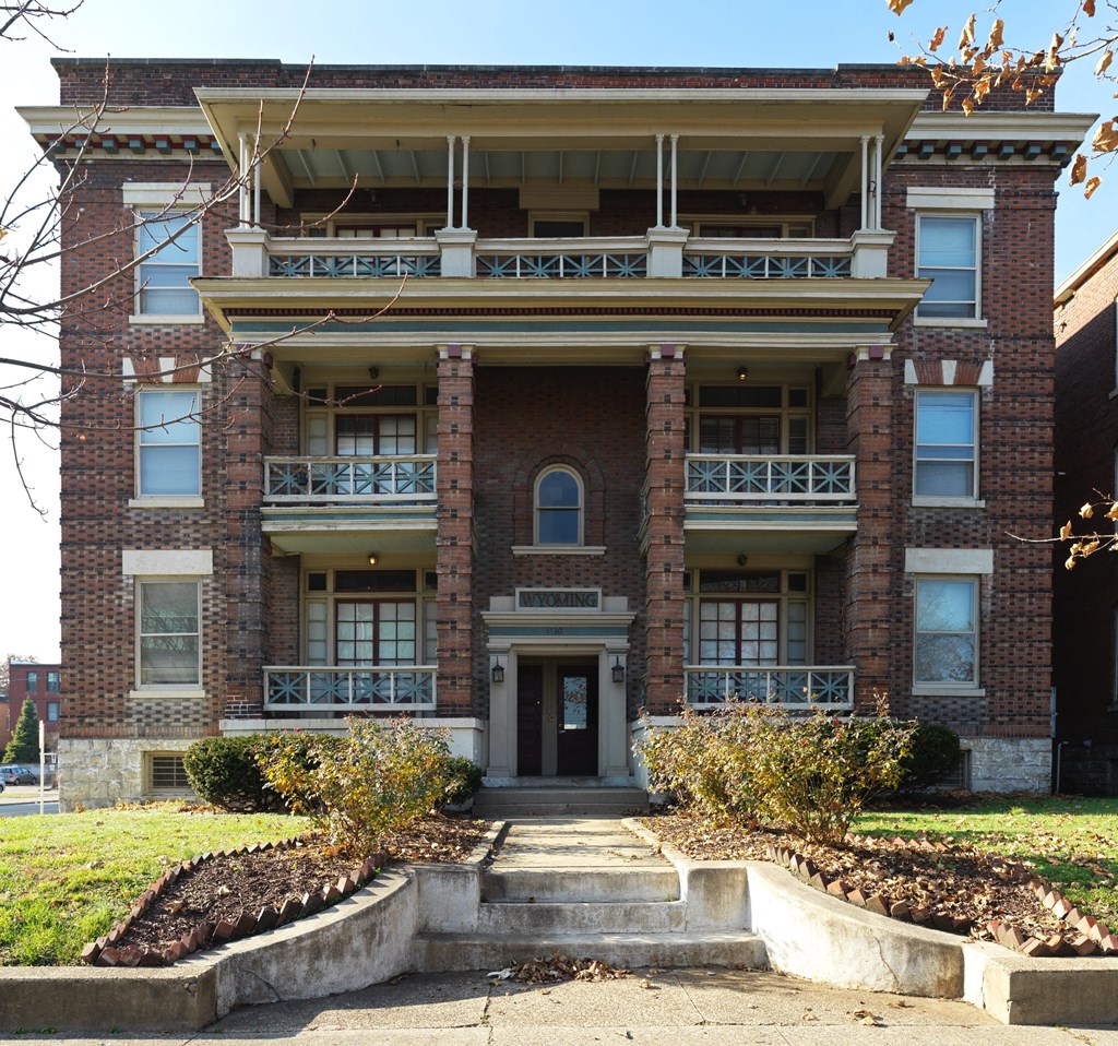 A large red brick building with a balcony on the second floor.