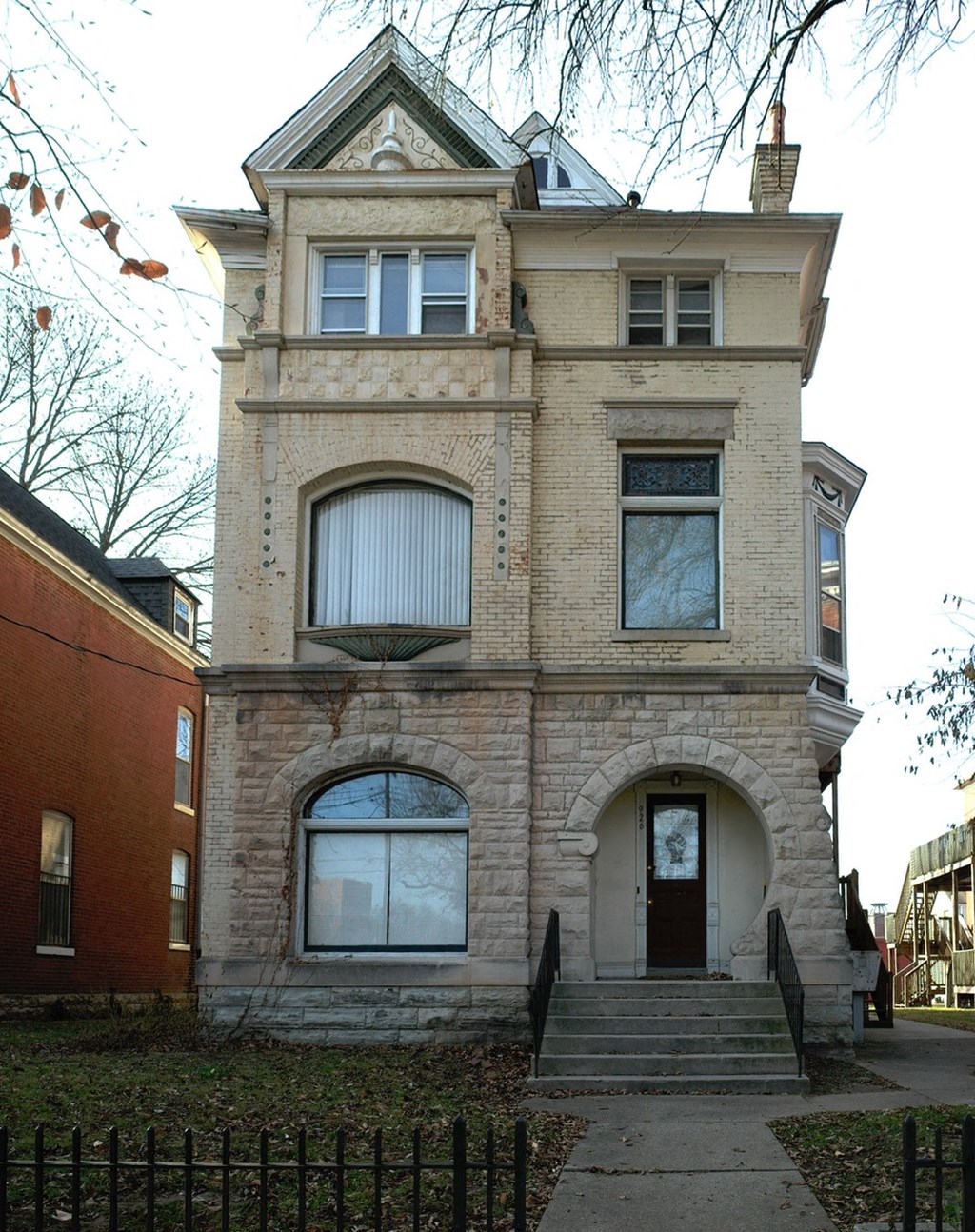 A two-story building with a brown door and a window on the first floor.