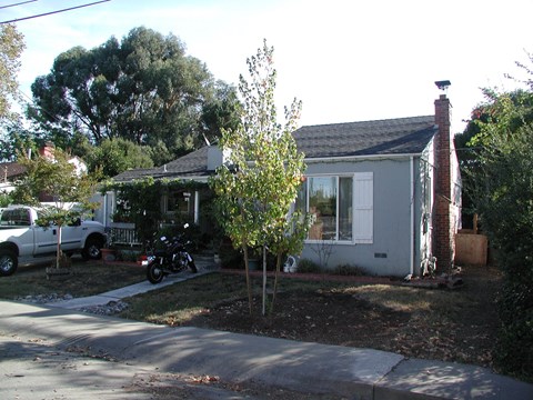 A small house with a tree in front of it.