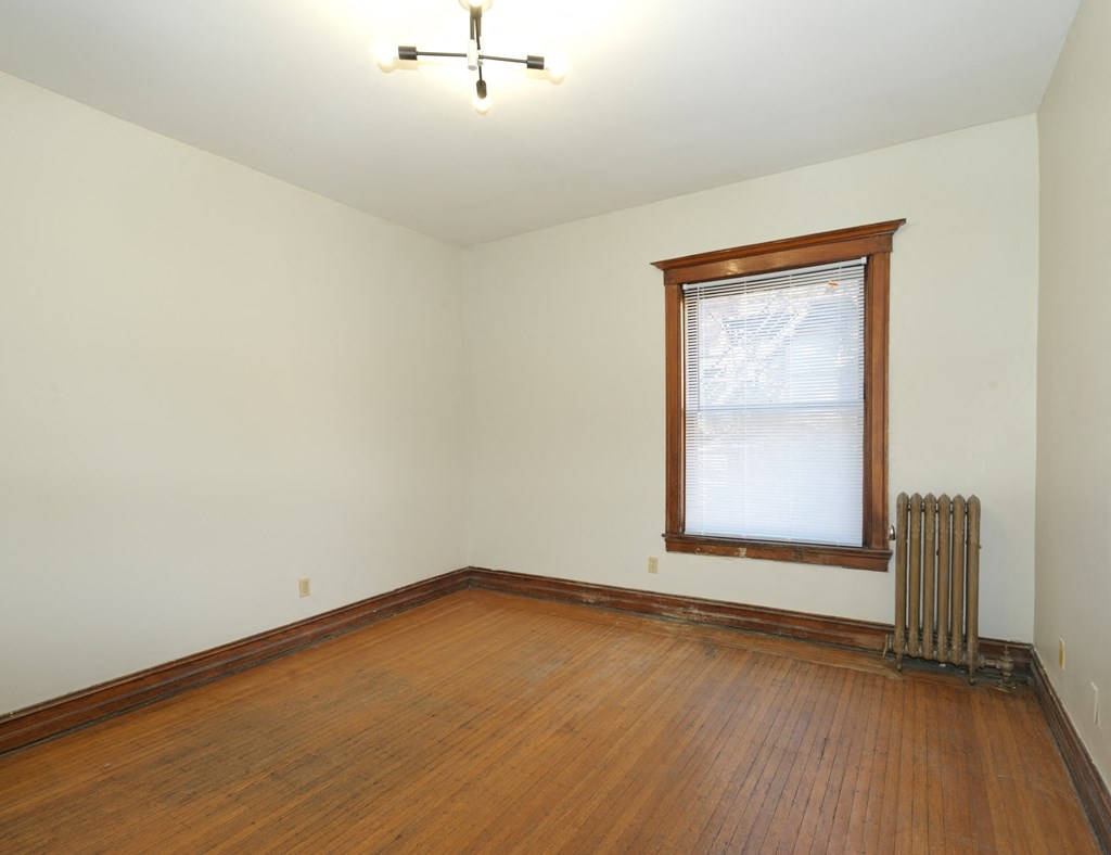 A room with a window and a radiator on the wall.