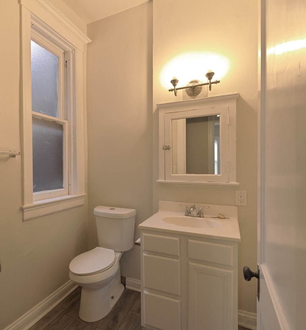 A white toilet sits next to a sink in a bathroom.