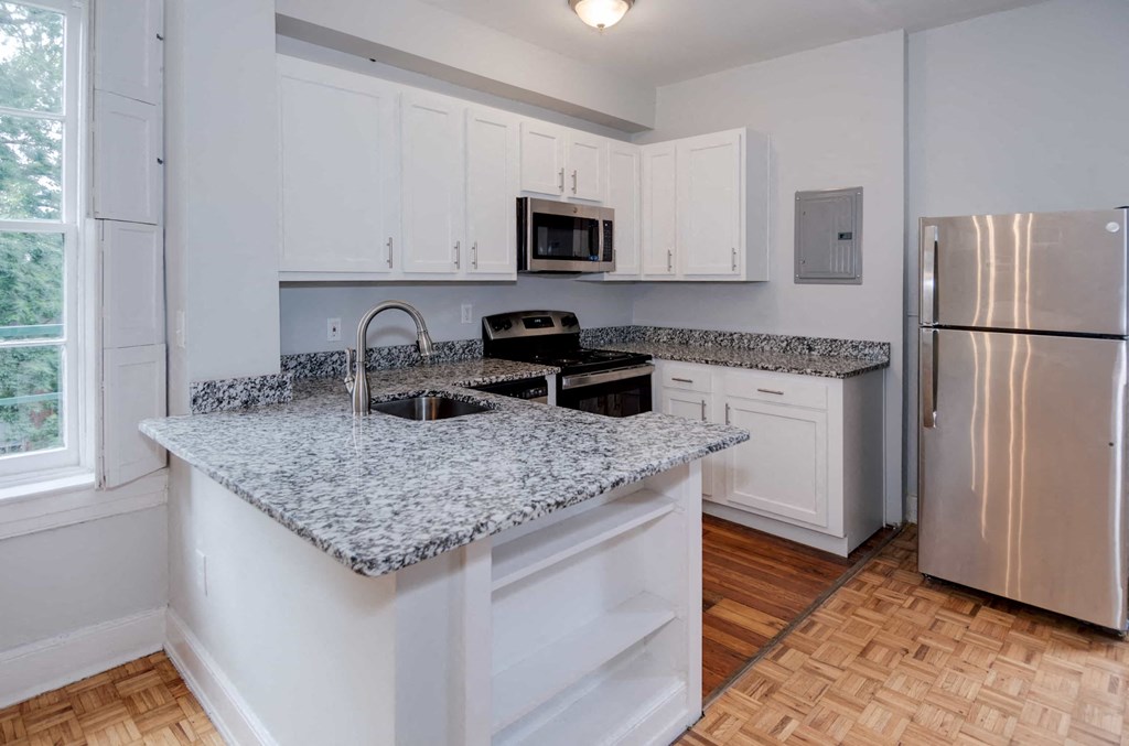 A kitchen with a granite countertop and stainless steel appliances.
