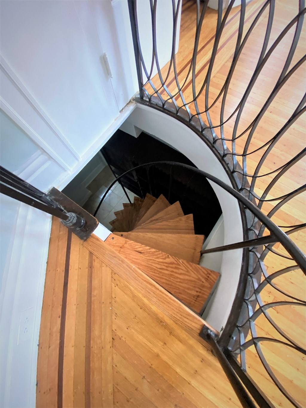 A spiral staircase with a metal railing and wooden steps.
