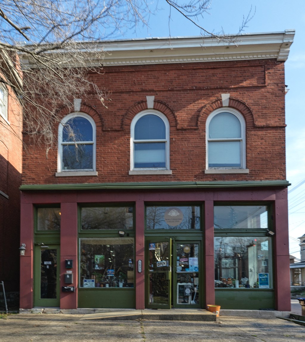 A red brick building with green doors and windows.