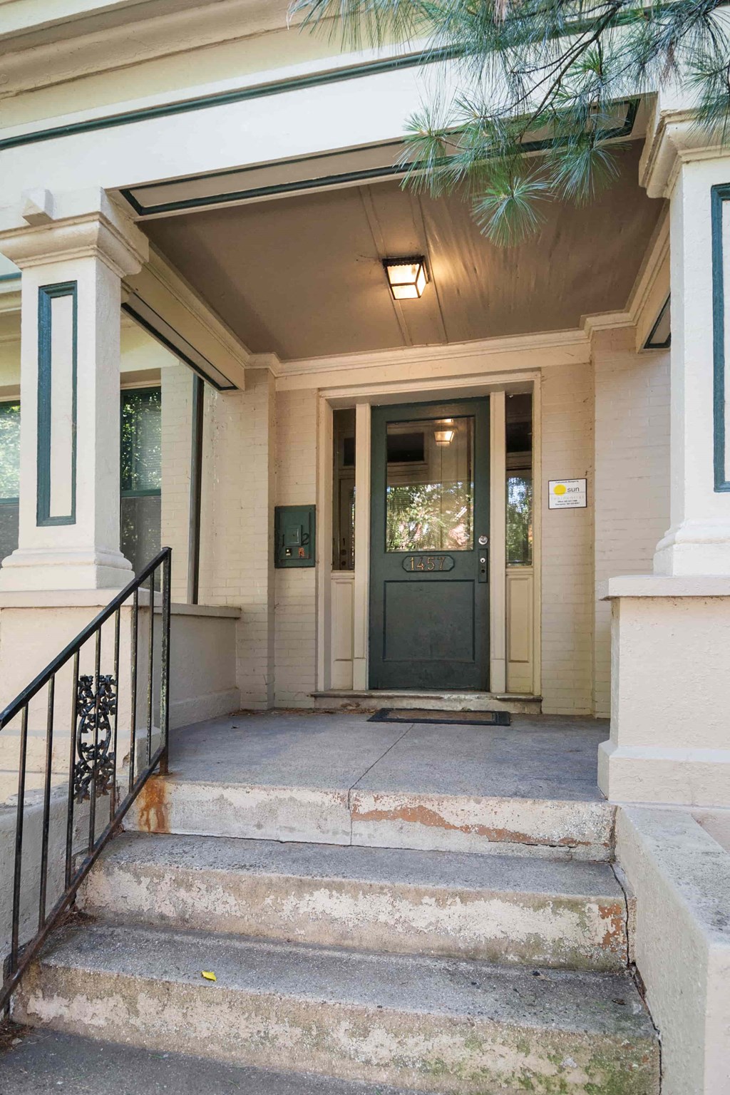 A black metal railing is on the left side of a concrete staircase.