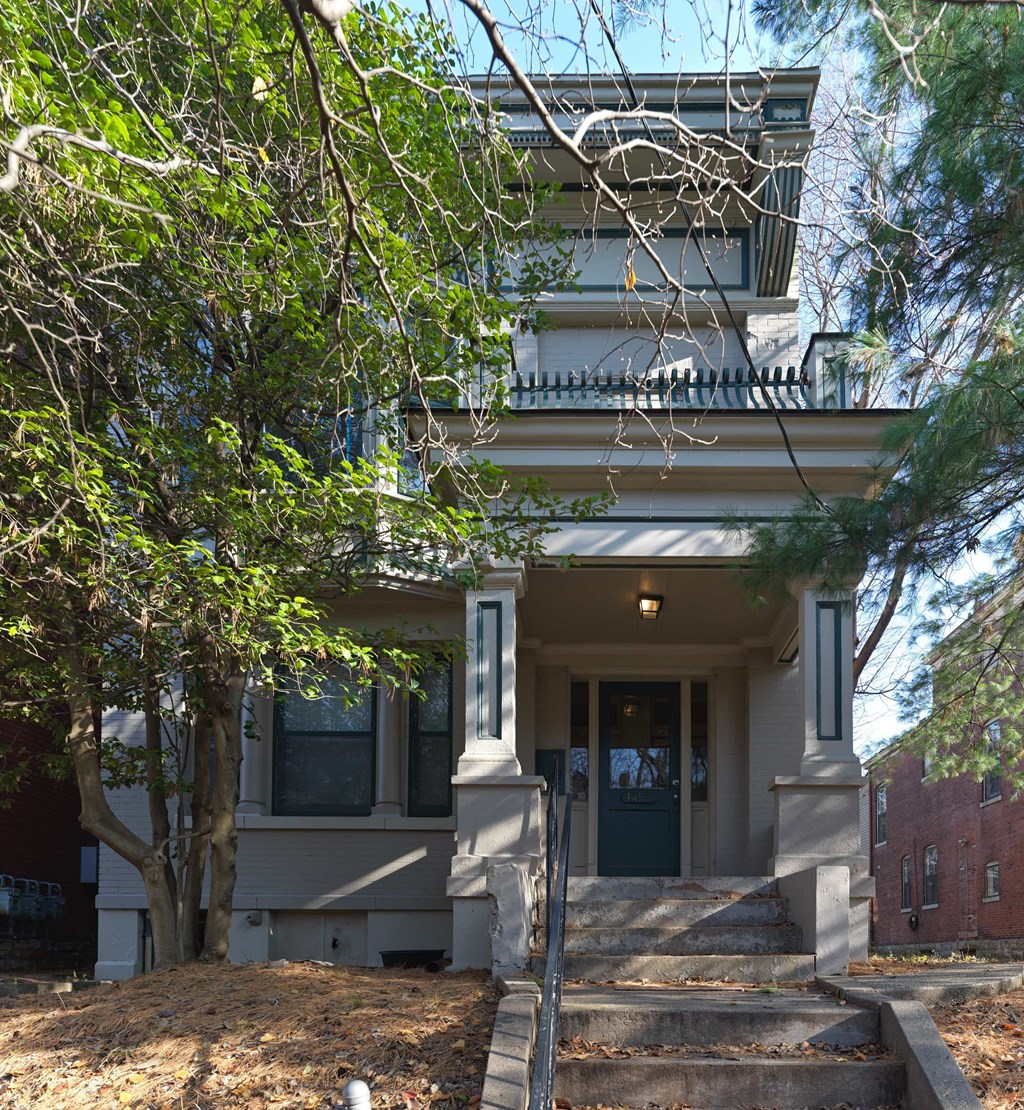 A house with a dark blue front door and a balcony.