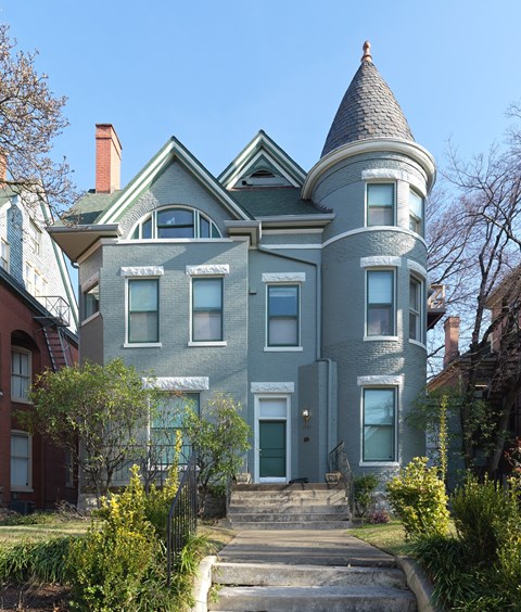 A large house with a tower and a front porch.