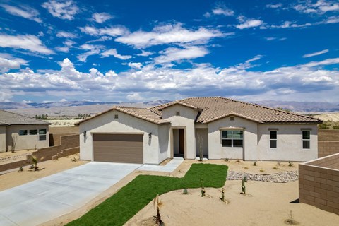 a house with a garage and a driveway in the desert