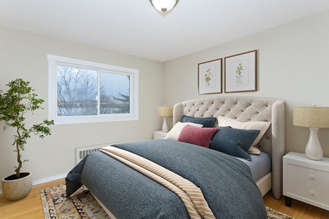 A bedroom with a large bed and a potted plant.