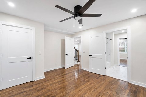 a living room with white walls and a ceiling fan