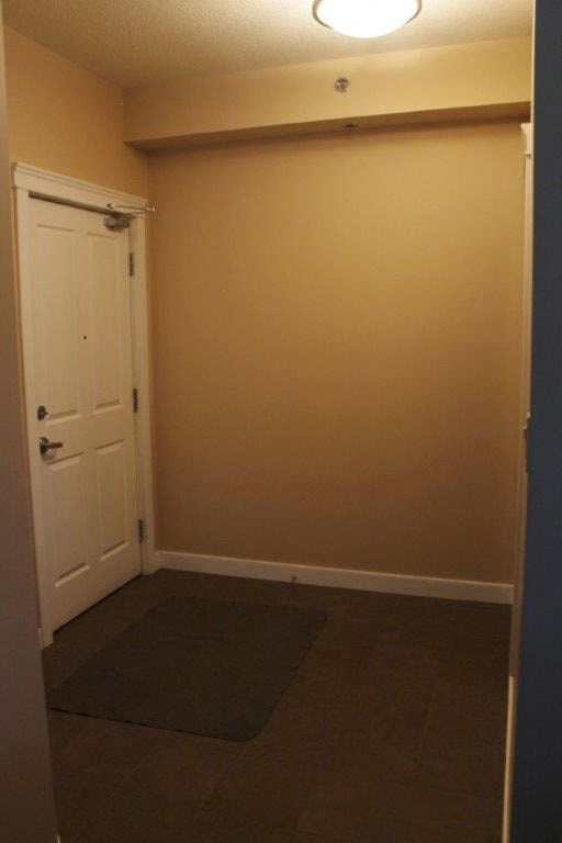 an empty room with a door and a rug