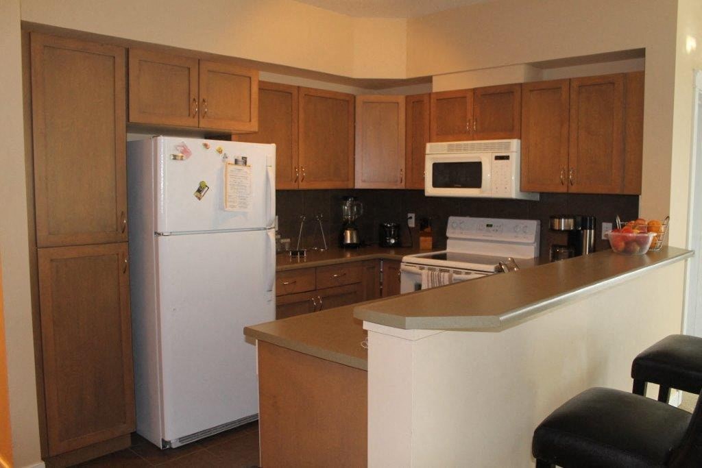 a kitchen with white appliances and wooden cabinets