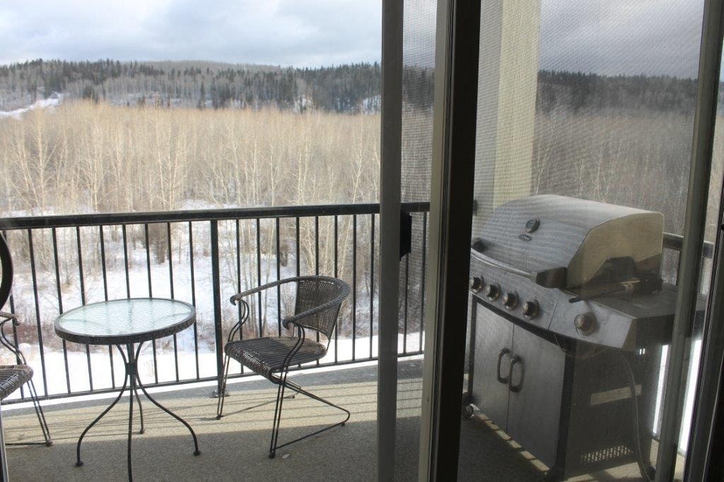 a balcony with a grill and a table